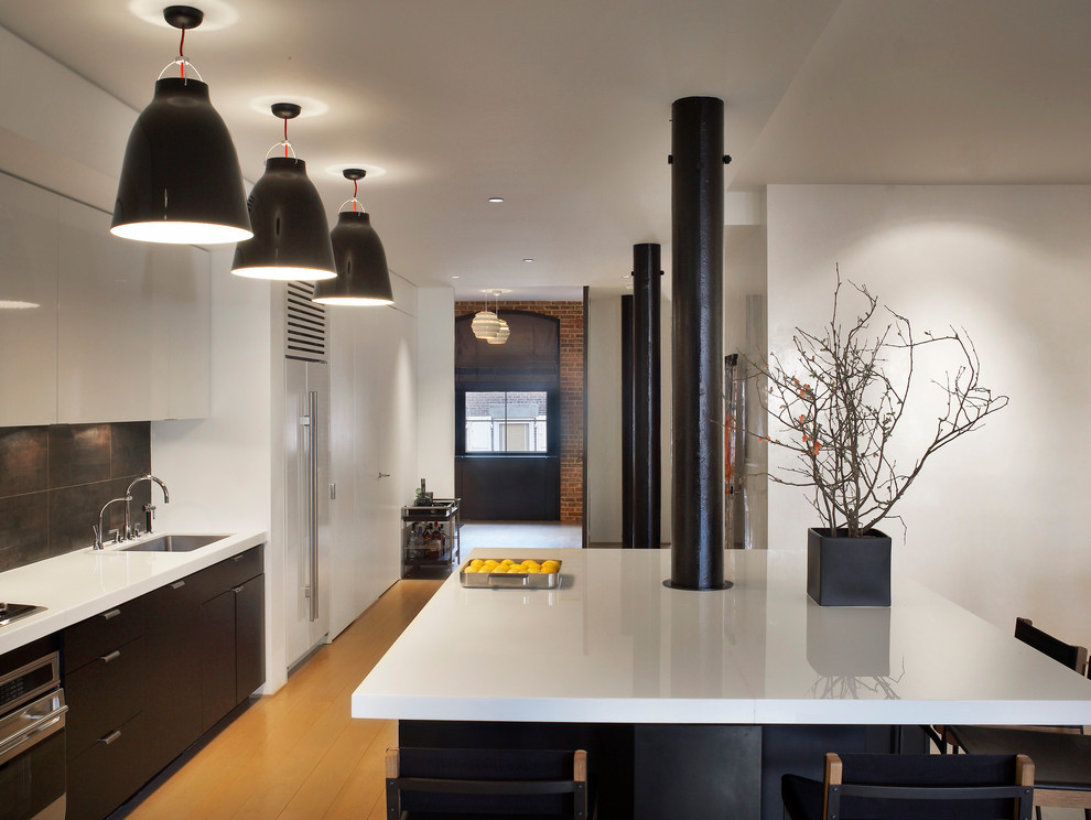 This is an example of a contemporary l-shaped open plan kitchen in New York with flat-panel cabinets.
