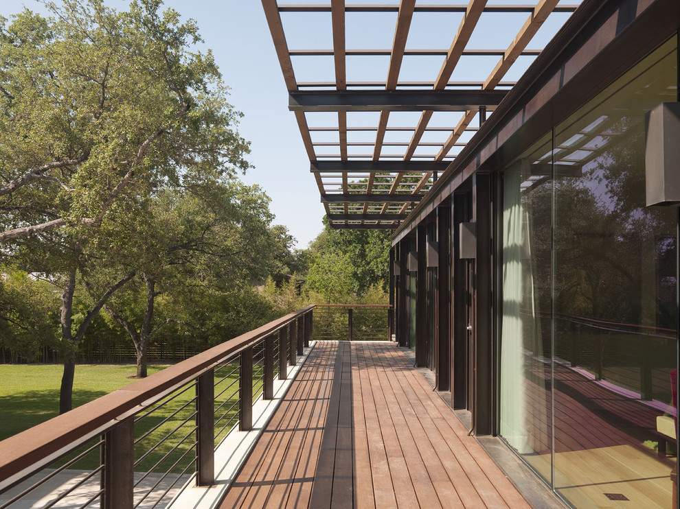 Inspiration for a mid-sized modern backyard deck in Austin with a pergola.