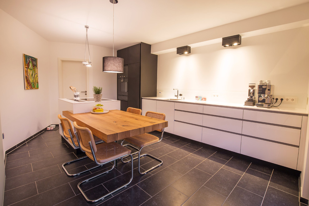 Photo of a contemporary separate kitchen in Cologne with quartz benchtops, glass sheet splashback and with island.
