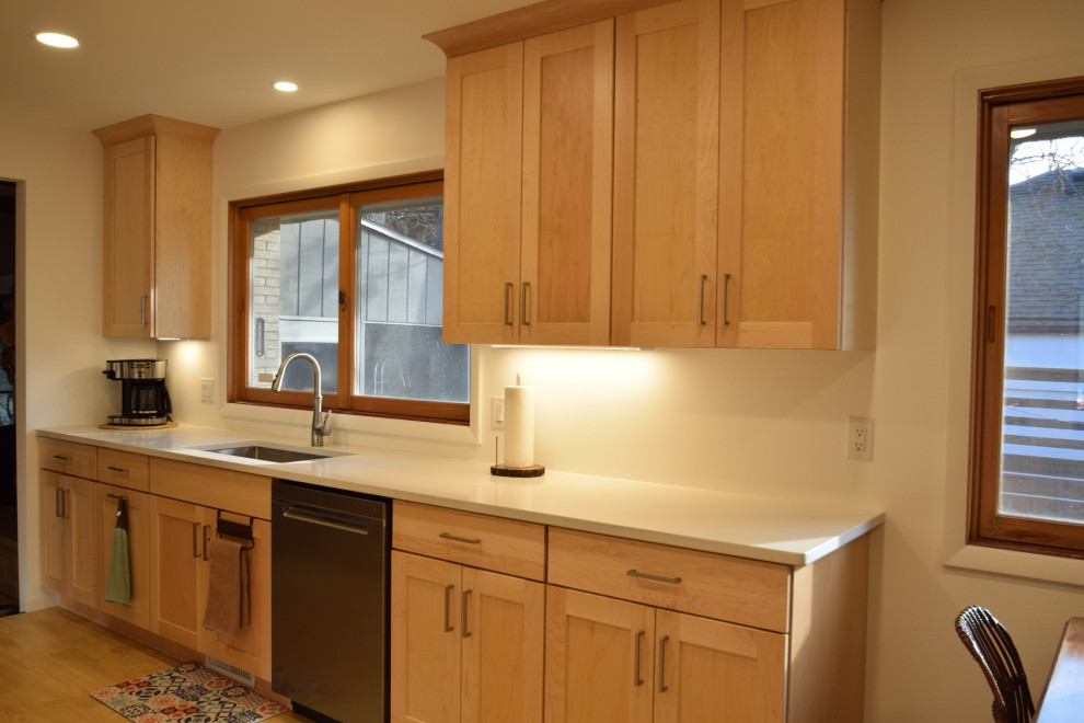 Kitchen - galley vinyl floor kitchen idea with an undermount sink, shaker cabinets, light wood cabinets, quartz countertops, stainless steel appliances and white countertops