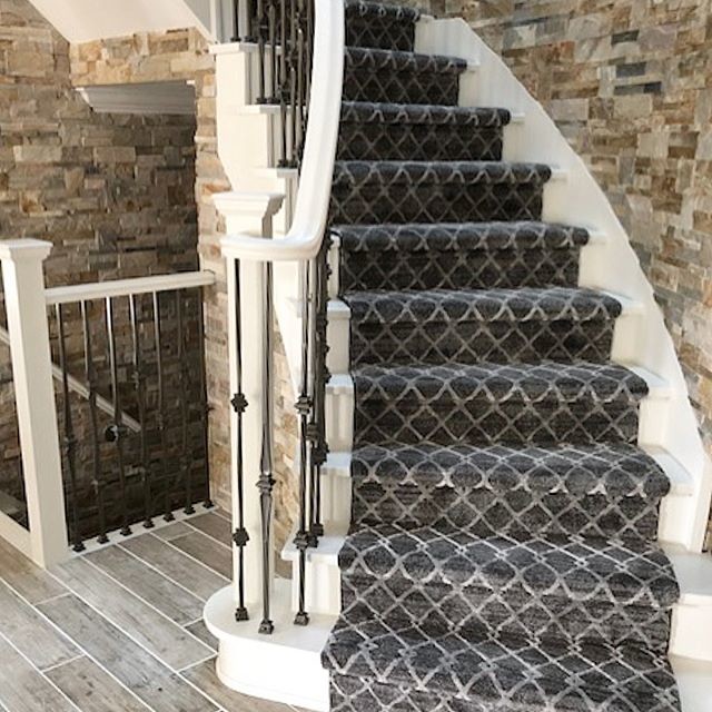 Huge transitional wooden curved metal railing staircase photo in Toronto with wooden risers