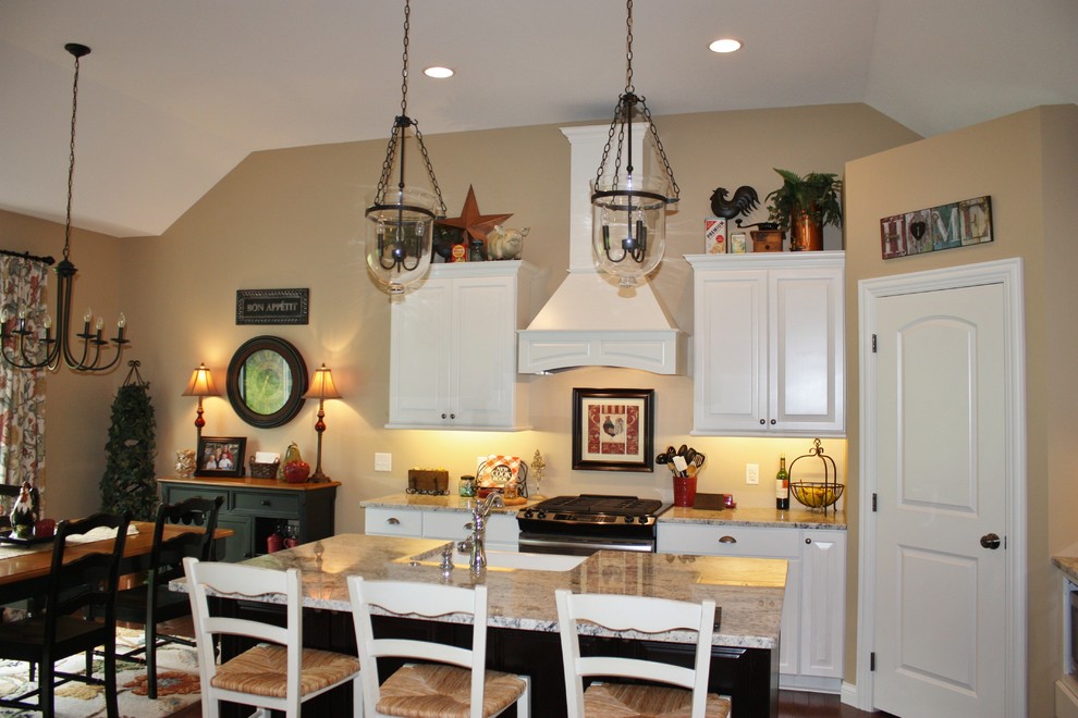 Transitional kitchen photo in Minneapolis with a farmhouse sink, white cabinets, stainless steel appliances and an island