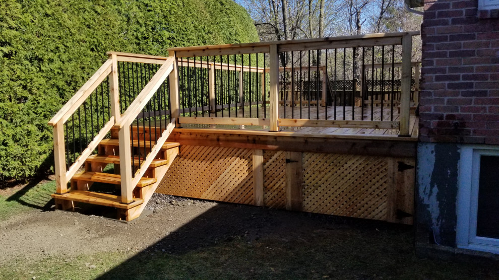 Inspiration for a large modern backyard and ground level deck in Ottawa with with skirting, no cover and mixed railing.