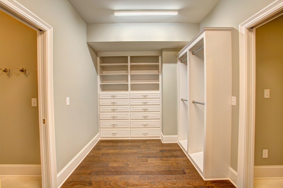 Large mediterranean gender-neutral walk-in wardrobe in Other with raised-panel cabinets, white cabinets and medium hardwood floors.