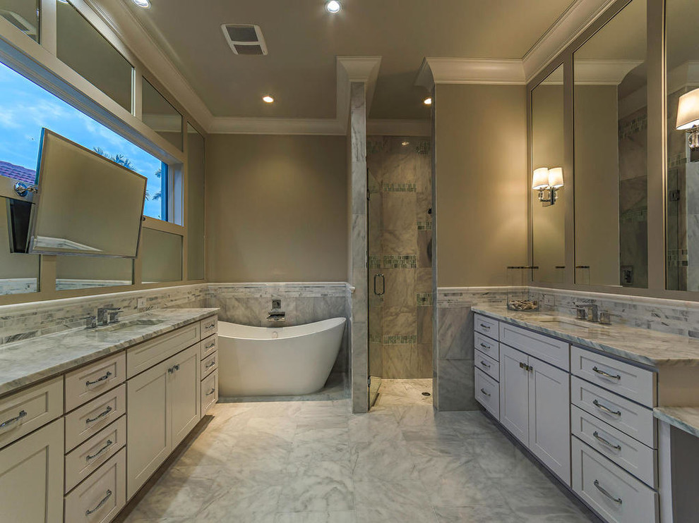 Design ideas for a large traditional master bathroom in Miami with shaker cabinets, white cabinets, a freestanding tub, an alcove shower, a one-piece toilet, white tile, porcelain tile, beige walls, porcelain floors, an integrated sink and engineered quartz benchtops.