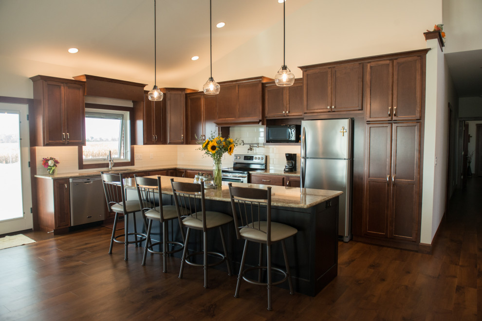 Inspiration for a large transitional l-shaped medium tone wood floor open concept kitchen remodel with an undermount sink, flat-panel cabinets, medium tone wood cabinets, quartz countertops, white backsplash, ceramic backsplash, stainless steel appliances, an island and multicolored countertops