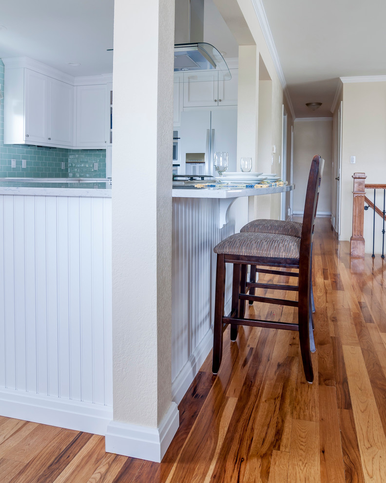 Mid-sized transitional medium tone wood floor eat-in kitchen photo in Denver with a single-bowl sink, flat-panel cabinets, yellow cabinets, quartz countertops, blue backsplash, glass tile backsplash, white appliances and an island