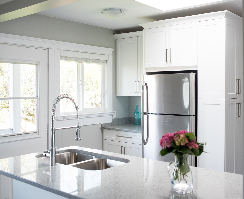 Mid-sized transitional l-shaped ceramic tile and gray floor eat-in kitchen photo in Vancouver with a double-bowl sink, shaker cabinets, white cabinets, granite countertops, stainless steel appliances, an island, gray backsplash and stone slab backsplash