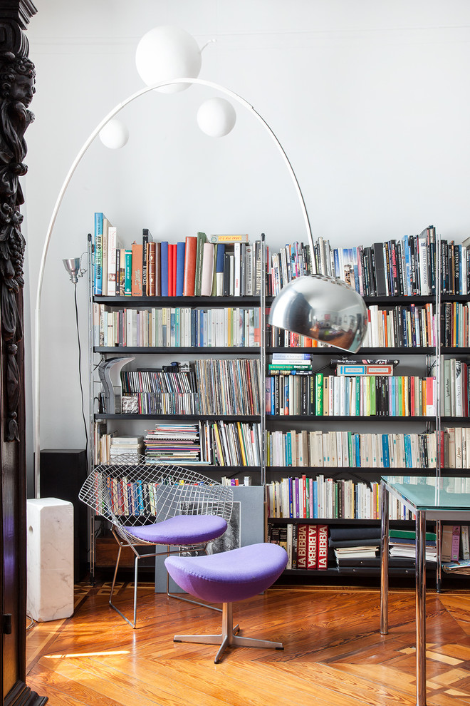 This is an example of a small eclectic family room in Milan with a library.