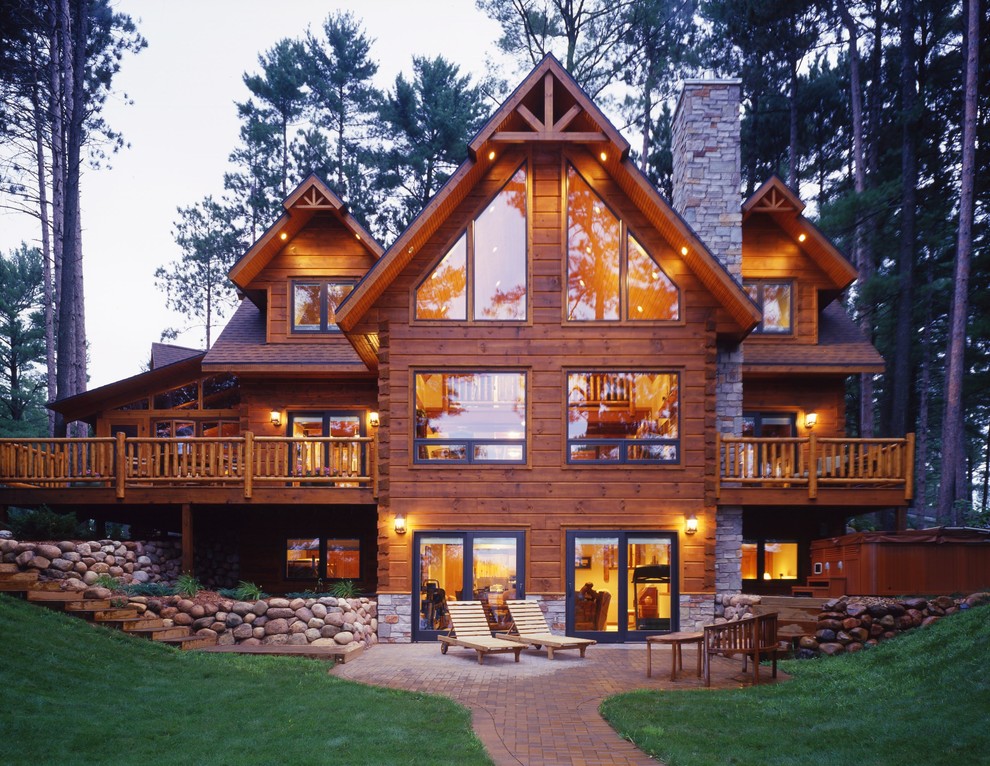 This is an example of a large country split-level brown exterior in Other with wood siding and a gable roof.