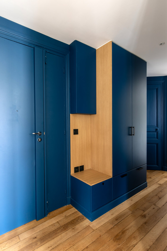 Foto de distribuidor contemporáneo de tamaño medio con paredes azules, suelo de madera clara, puerta doble y puerta azul