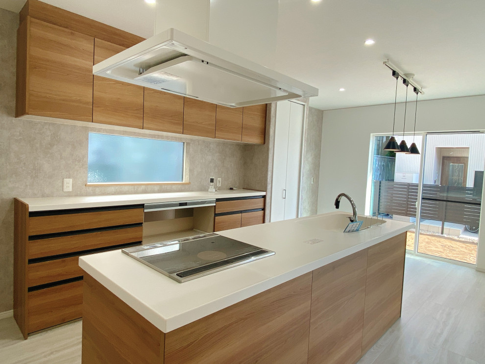Modelo de cocina lineal moderna abierta con fregadero integrado, salpicadero marrón, salpicadero de madera, una isla, suelo blanco, encimeras blancas y papel pintado