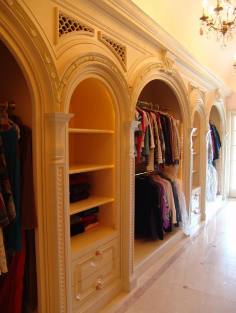 Design ideas for a mediterranean women's dressing room in Dallas with raised-panel cabinets, light wood cabinets and marble floors.