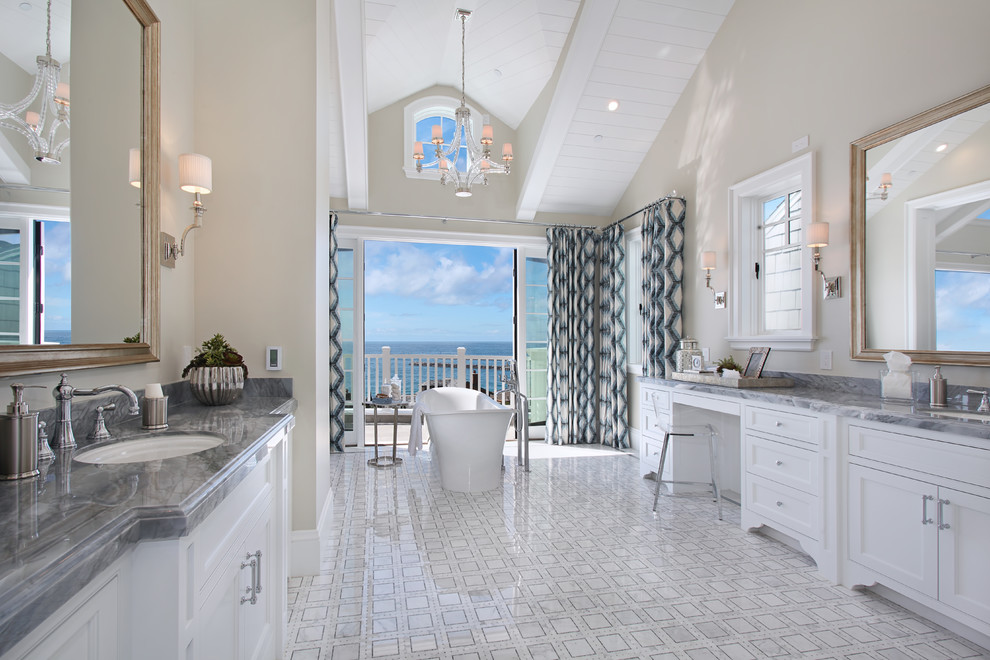 Design ideas for an expansive transitional master bathroom in Orange County with shaker cabinets, white cabinets, beige walls, marble floors, an undermount sink, marble benchtops, white floor, a freestanding tub, an alcove shower and a hinged shower door.