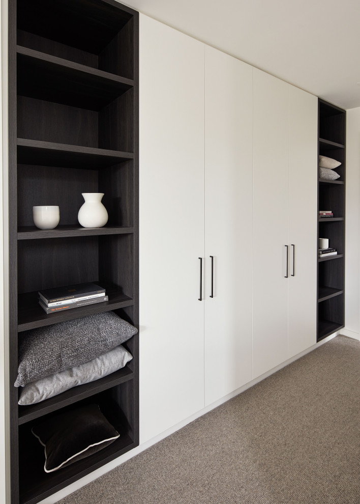 This is an example of a mid-sized contemporary study room in Melbourne with white walls, carpet, a built-in desk and grey floor.