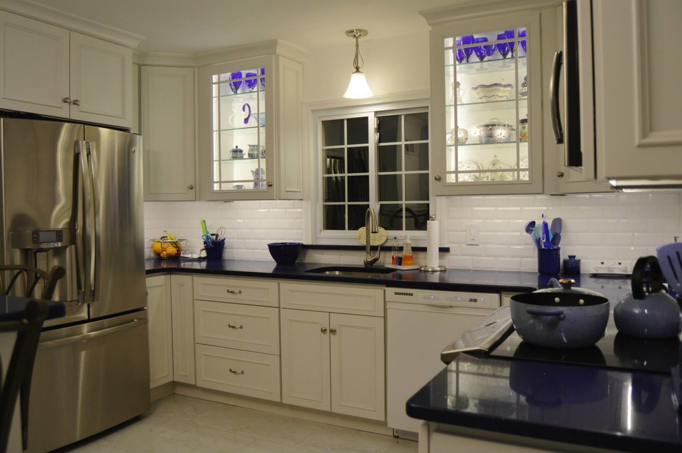 Example of a large u-shaped porcelain tile eat-in kitchen design in Boston with white cabinets, white backsplash, stainless steel appliances, an island, a single-bowl sink, recessed-panel cabinets, quartz countertops and cement tile backsplash