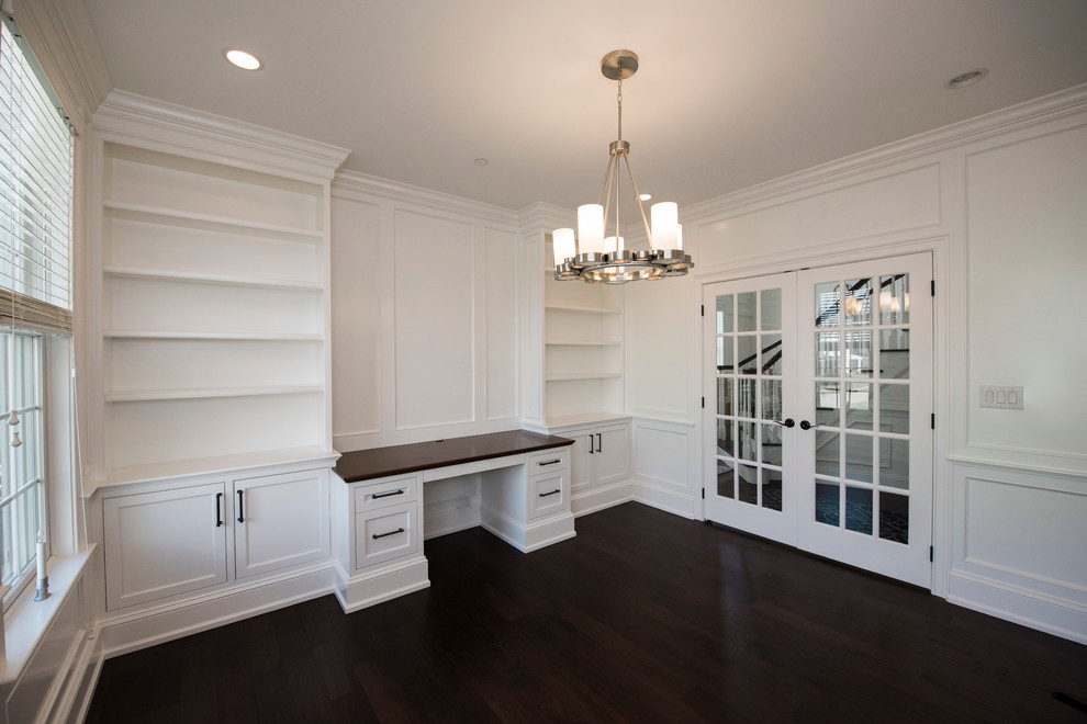 Photo of a mid-sized transitional study room in Philadelphia with white walls, dark hardwood floors and a built-in desk.