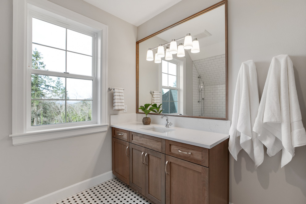 Design ideas for a mid-sized transitional 3/4 bathroom in Portland with shaker cabinets, medium wood cabinets, an alcove tub, a shower/bathtub combo, a one-piece toilet, white tile, ceramic tile, grey walls, ceramic floors, a drop-in sink, engineered quartz benchtops, white floor, a shower curtain, white benchtops, a niche, a single vanity and a built-in vanity.