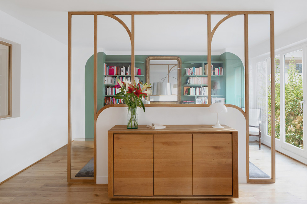 Ispirazione per un soggiorno minimal di medie dimensioni con libreria, parquet chiaro e nessuna TV