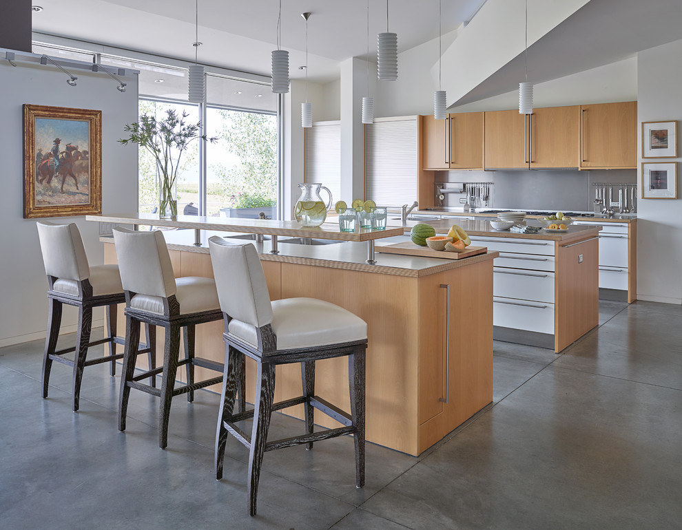 Contemporary galley kitchen in Other with flat-panel cabinets, white cabinets, concrete floors and multiple islands.