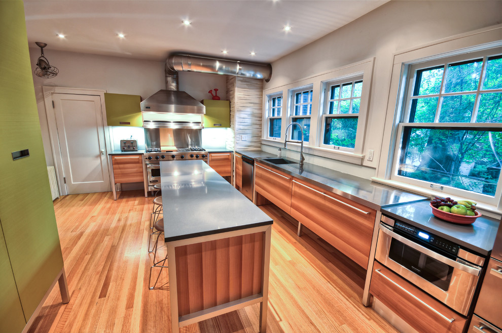Eclectic kitchen in Cleveland with stainless steel appliances, stainless steel benchtops and an integrated sink.