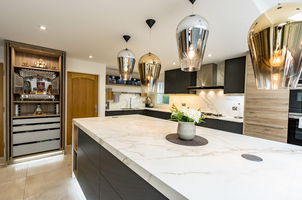 This is an example of a large modern l-shaped open plan kitchen in Surrey with an integrated sink, flat-panel cabinets, grey cabinets, solid surface benchtops, white splashback, slate splashback, stainless steel appliances, porcelain floors, with island and grey floor.