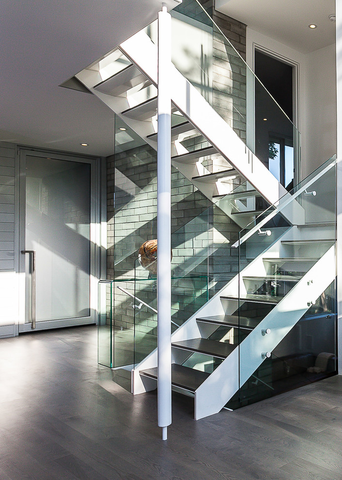 This is an example of a large modern metal floating staircase in Other with open risers and glass railing.