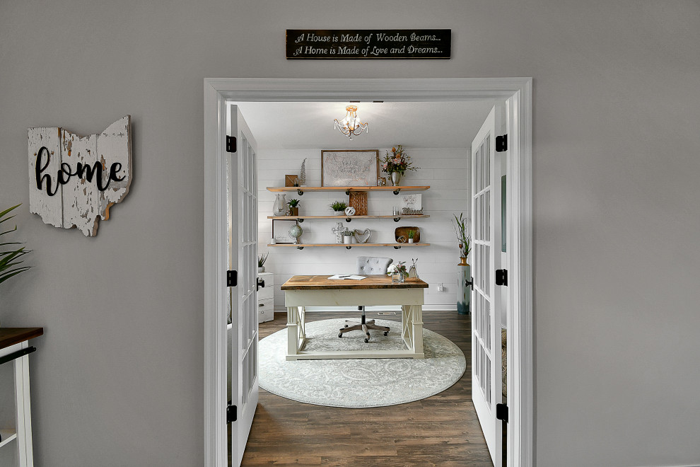 Cette image montre un bureau rustique de taille moyenne avec un mur gris, un sol en vinyl, un bureau indépendant, un sol marron et du lambris de bois.