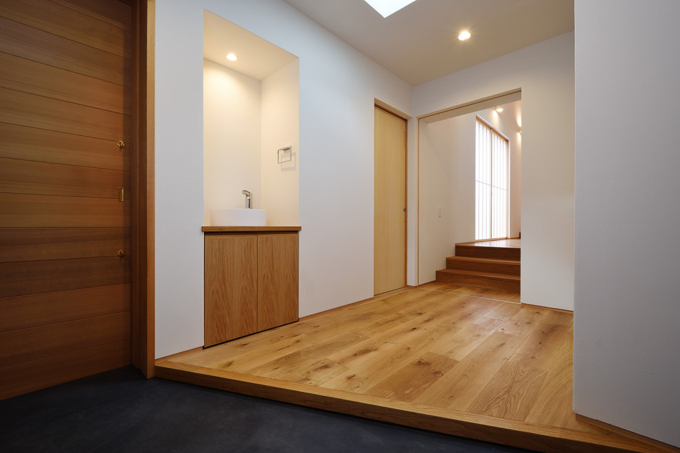 Large entry hall in Other with white walls, medium hardwood floors, a sliding front door and a medium wood front door.