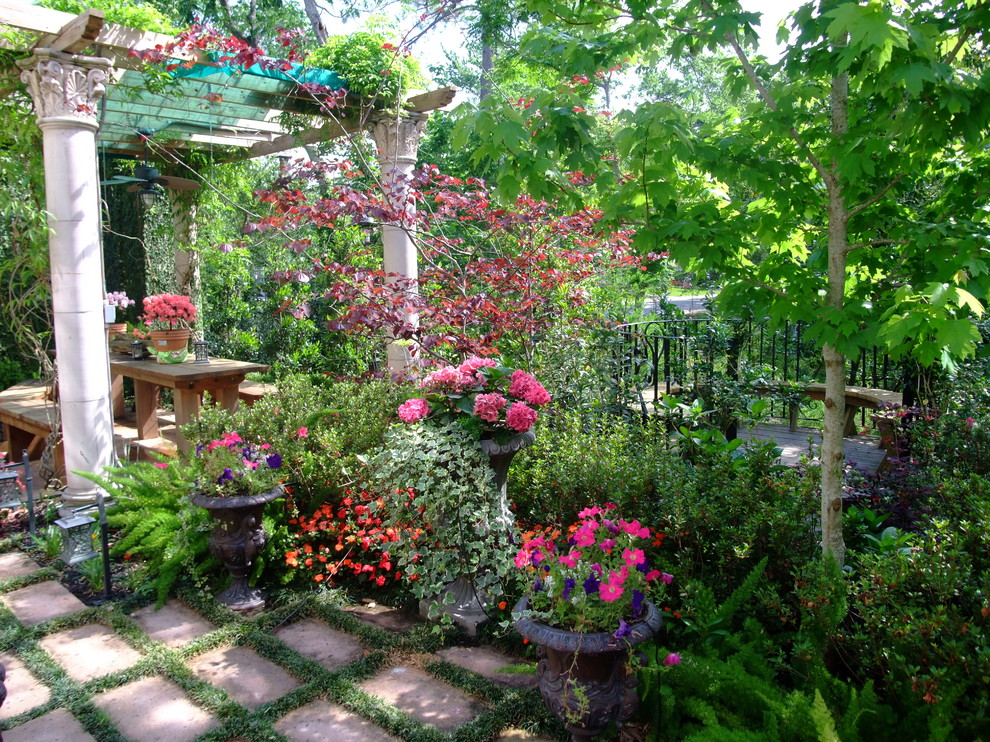 Mediterranean backyard shaded garden in Houston with a container garden for summer.