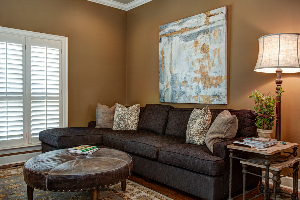 This is an example of a mid-sized transitional open concept family room in Little Rock with brown walls, dark hardwood floors, a wall-mounted tv and brown floor.