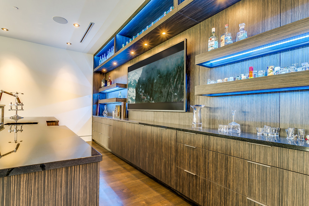 Modern wet bar in Dallas with glass benchtops, medium wood cabinets and flat-panel cabinets.