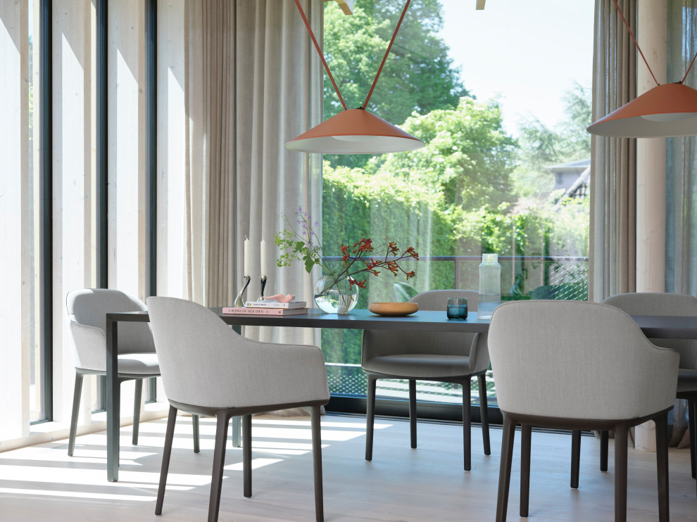 Modernes Esszimmer mit hellem Holzboden und beigem Boden in Hamburg