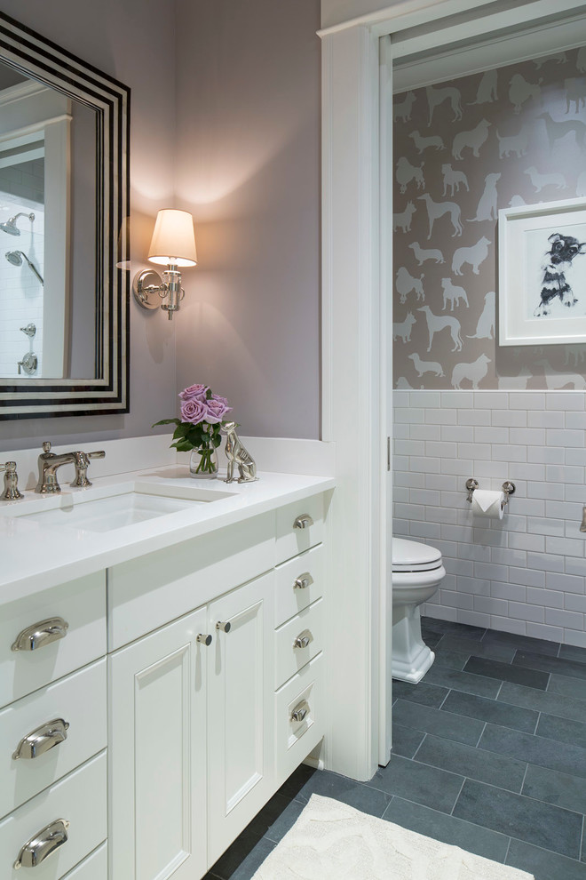 Photo of a mid-sized transitional powder room in Minneapolis with white cabinets, slate floors, grey floor, recessed-panel cabinets, a two-piece toilet, white tile, subway tile, purple walls, an undermount sink and quartzite benchtops.