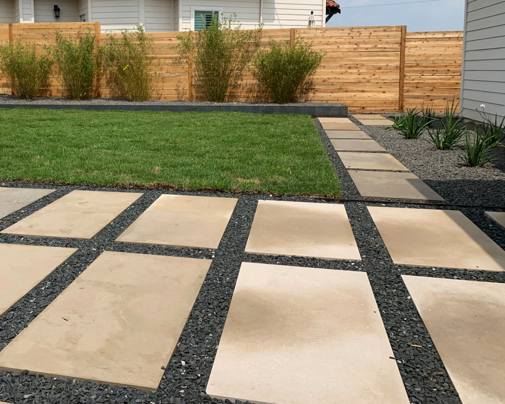 Immagine di un giardino xeriscape design esposto in pieno sole di medie dimensioni e dietro casa in estate con un giardino in vaso, pavimentazioni in cemento e recinzione in legno