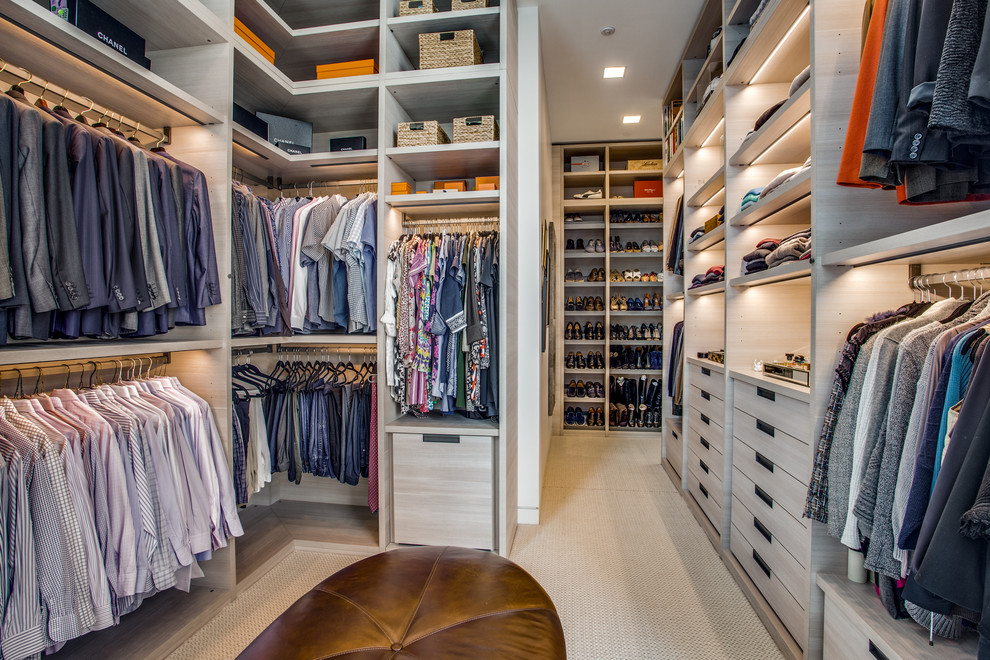 Expansive contemporary walk-in wardrobe in Dallas with flat-panel cabinets, light wood cabinets, carpet and beige floor.