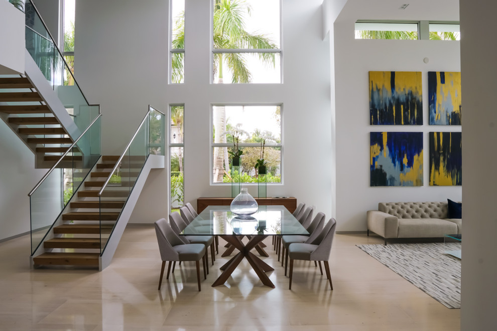 This is an example of a contemporary open plan dining in Miami with white walls and beige floor.