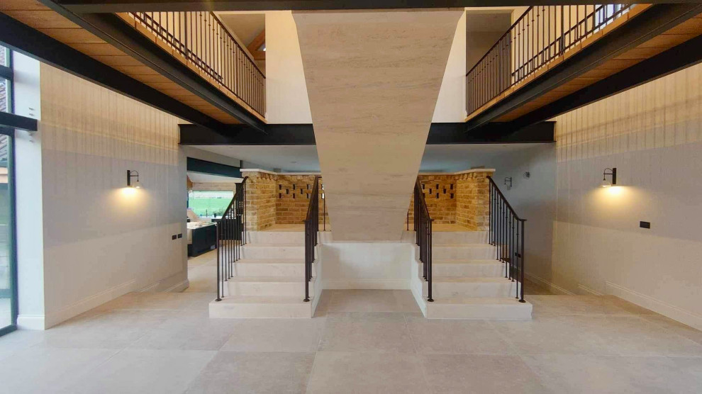 Стильный дизайн: лестница на больцах, среднего размера в стиле модернизм с ступенями из травертина, подступенками из травертина и металлическими перилами - последний тренд