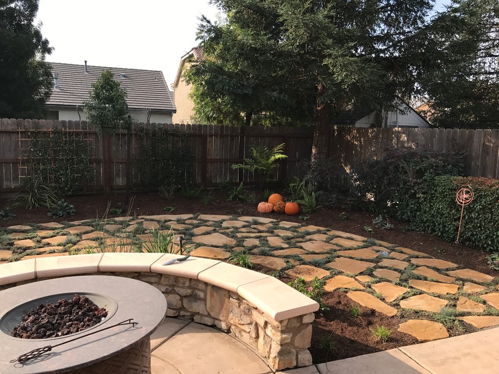 Patio - mid-sized transitional backyard stone patio idea with a fire pit and no cover