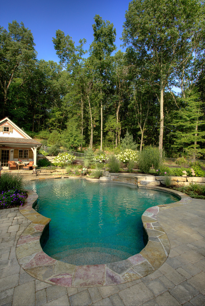 Inspiration for a mid-sized arts and crafts side yard custom-shaped natural pool in Detroit with a pool house and brick pavers.