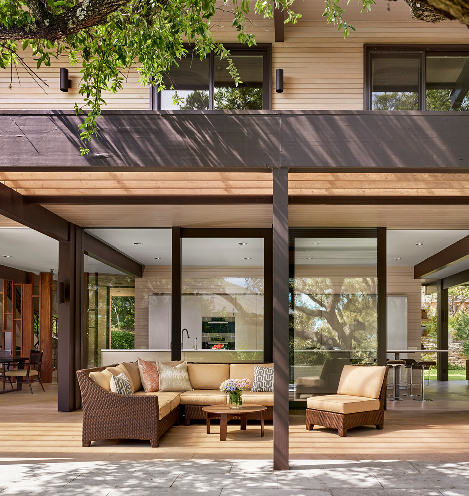 This is an example of a large contemporary backyard patio in Austin with decking, a pergola and a water feature.