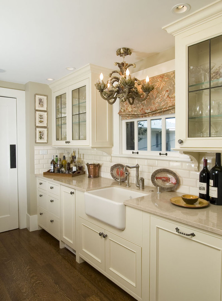 Photo of a traditional kitchen in San Francisco with beaded inset cabinets, a farmhouse sink, beige cabinets, white splashback and subway tile splashback.