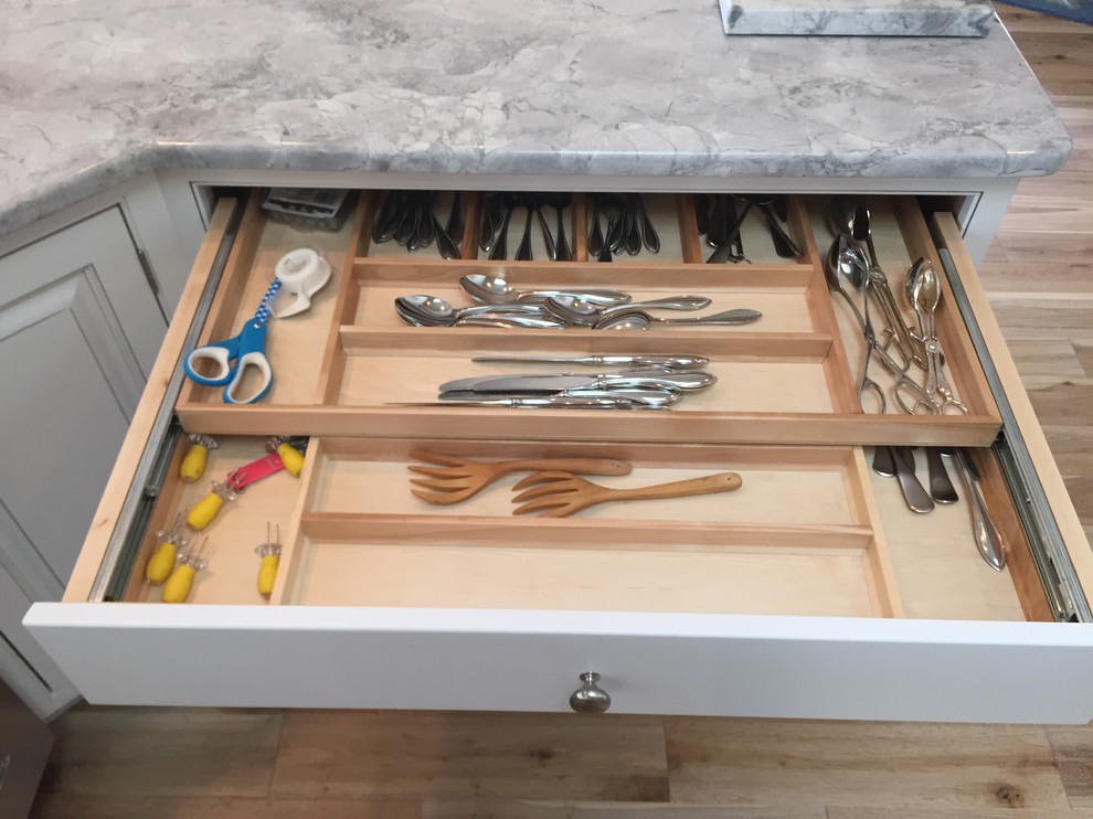 Example of a large transitional u-shaped light wood floor open concept kitchen design with an undermount sink, beaded inset cabinets, white cabinets, white appliances and a peninsula