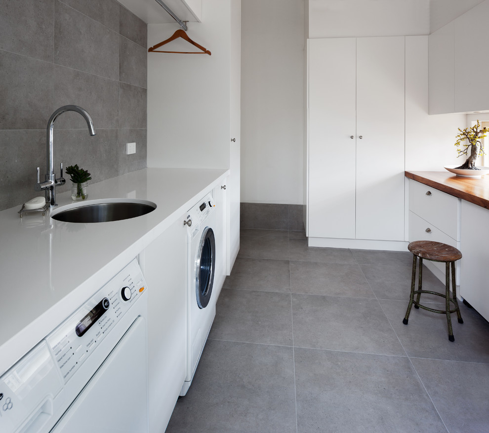 Photo of a contemporary laundry room in Perth with an undermount sink, flat-panel cabinets, white cabinets, quartz benchtops and white benchtop.
