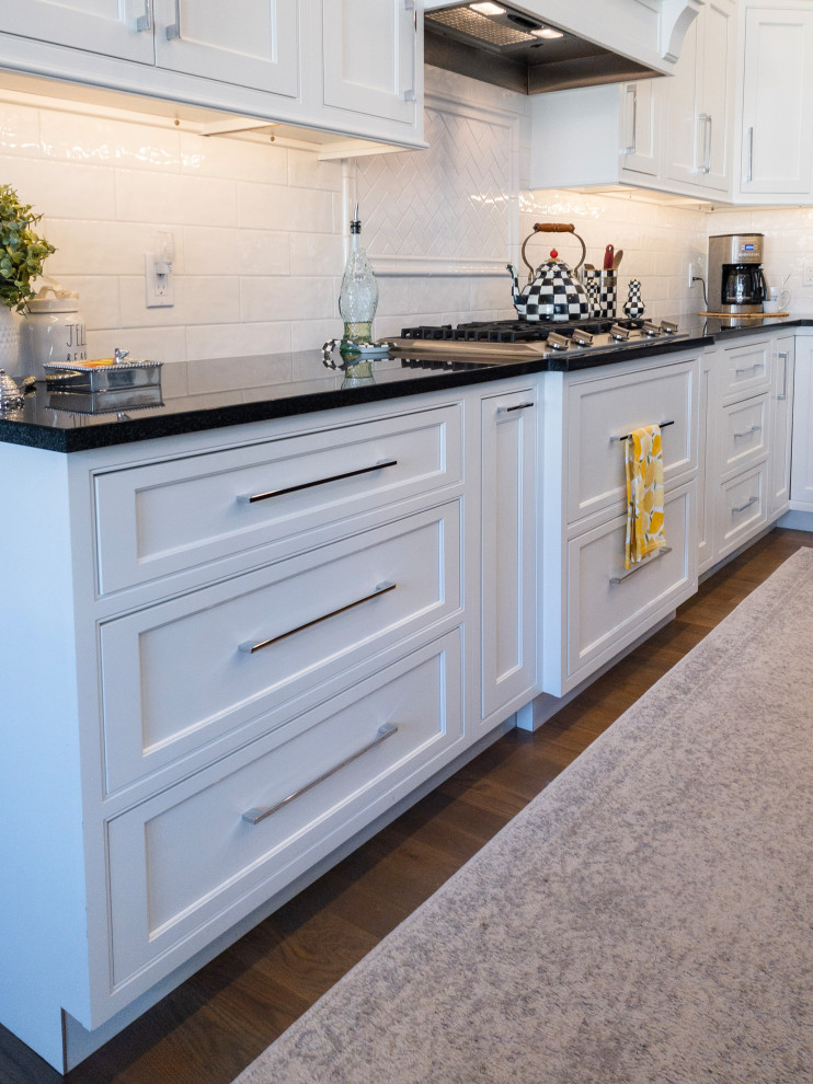 Example of a large transitional l-shaped medium tone wood floor, gray floor and shiplap ceiling eat-in kitchen design with an undermount sink, flat-panel cabinets, white cabinets, granite countertops, yellow backsplash, subway tile backsplash, stainless steel appliances, an island and white countertops
