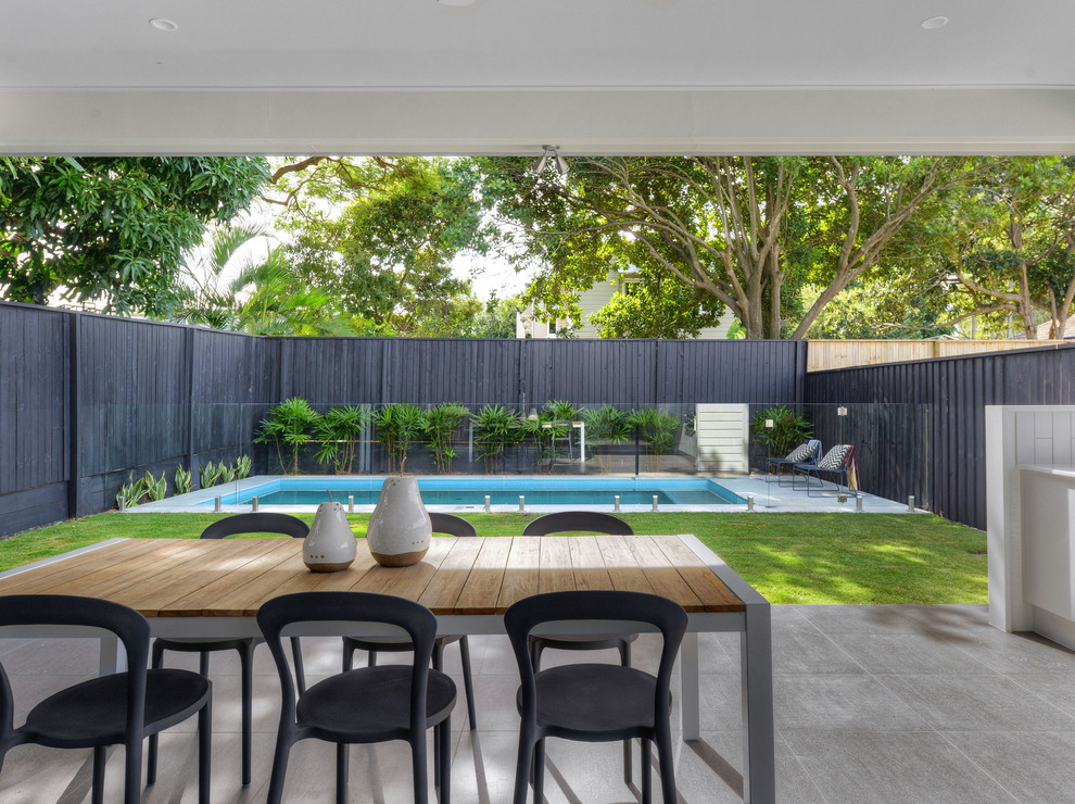 Inspiration for a transitional backyard patio in Brisbane with concrete pavers and an awning.