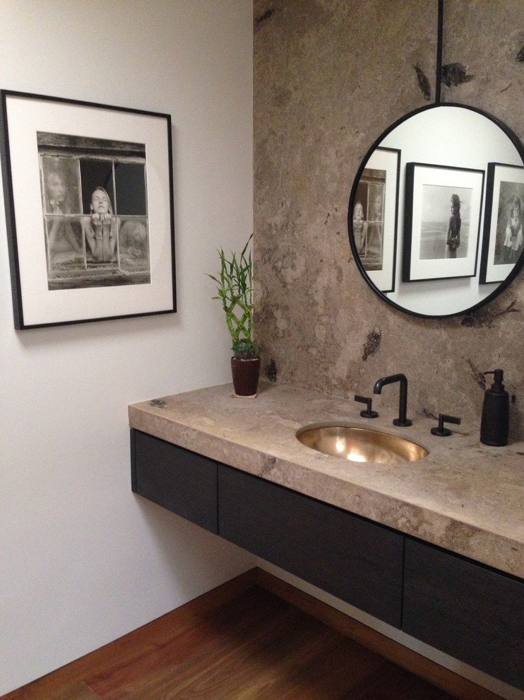 Mid-sized contemporary powder room in Santa Barbara with an undermount sink, flat-panel cabinets, dark wood cabinets, white walls and medium hardwood floors.