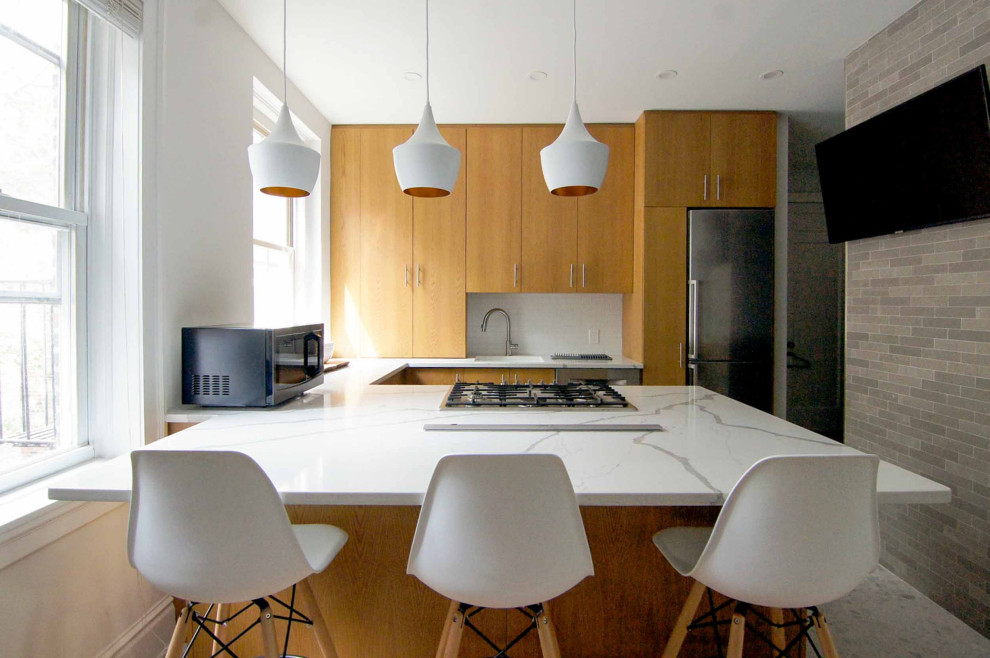 Design ideas for a small midcentury u-shaped eat-in kitchen in New York with flat-panel cabinets, medium wood cabinets, quartzite benchtops, white splashback, ceramic splashback, stainless steel appliances, a peninsula and white benchtop.