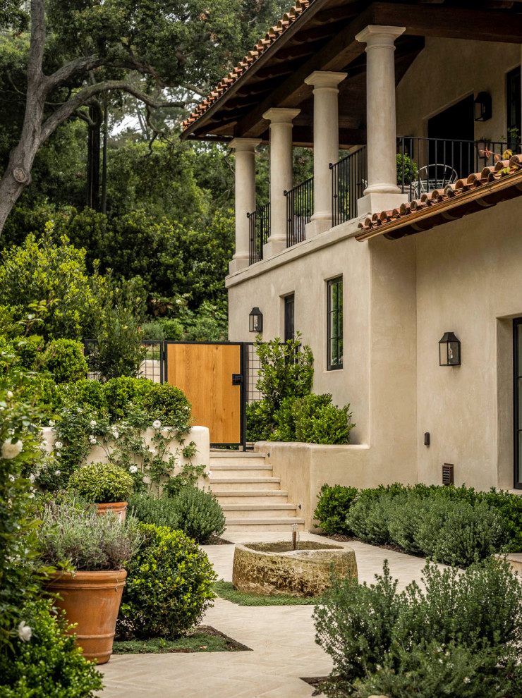 Idee per un grande giardino formale mediterraneo esposto in pieno sole con pavimentazioni in pietra naturale e fontane