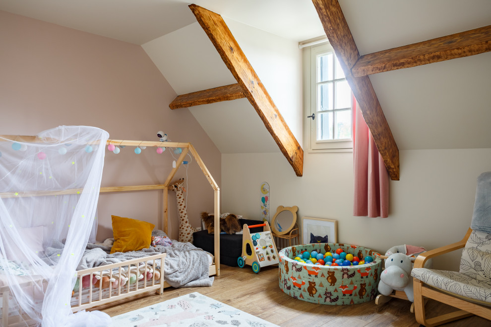 Immagine di una cameretta per bambini da 1 a 3 anni nordica con pareti rosa e travi a vista